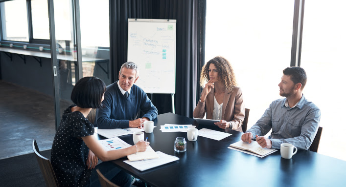 A team sits around a table having a meeting.